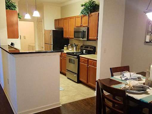 A kitchen with wooden cabinets and a black refrigerator.
