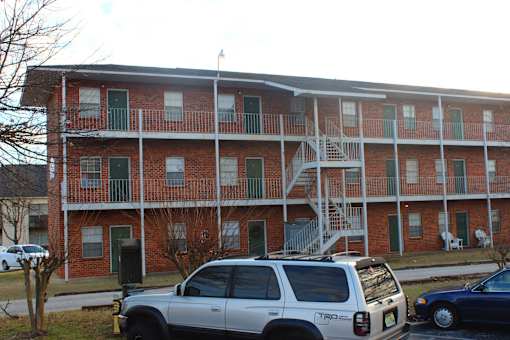 an apartment building with cars parked in front of it