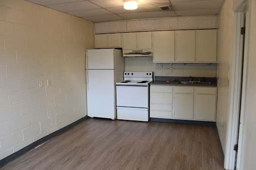 an empty kitchen with a stove refrigerator and