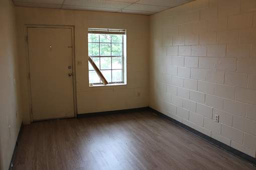 an empty room with wooden floors and a window