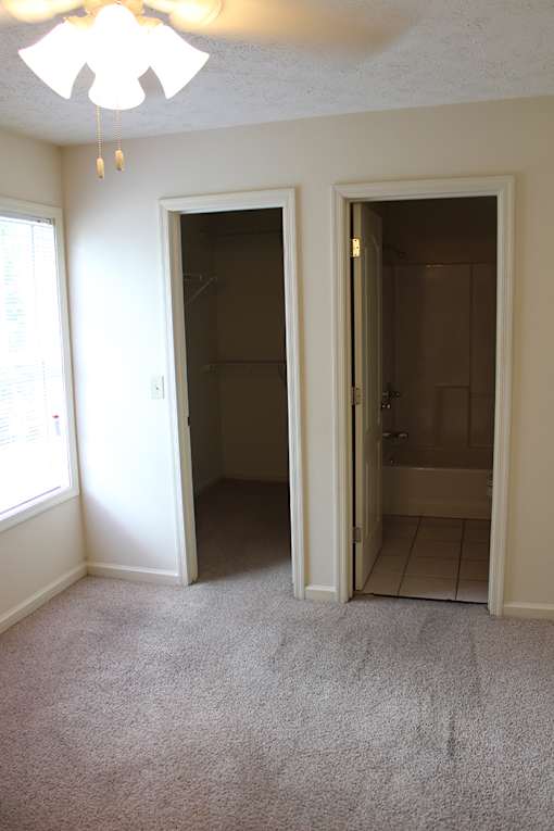 a bedroom with a closet and a door to a bathroom