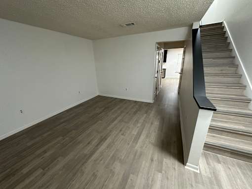 A room with a staircase and wooden flooring.