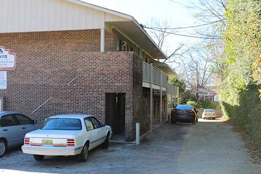 a brick building with cars parked outside of it