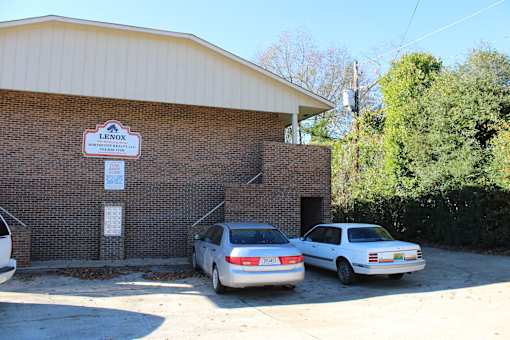 a brick building with two cars parked in front of it