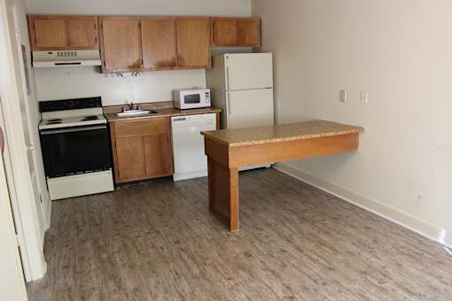 an empty kitchen with a desk in the middle of it