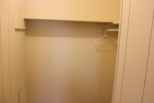 an empty closet with a hanger in it