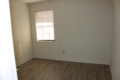 an empty room with white walls and a window