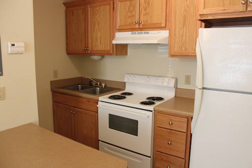 a kitchen with white appliances and wooden cabinets