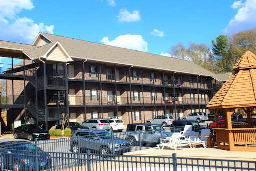 an exterior view of a building with cars in a parking lot