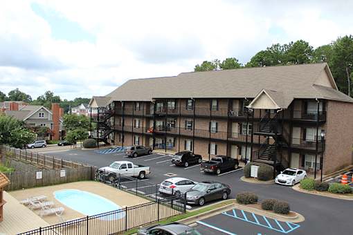 a view of an apartment building with cars parked in a parking lot