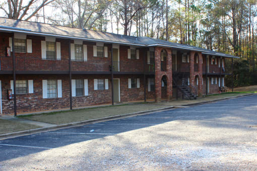 the front of a brick building with a parking lot
