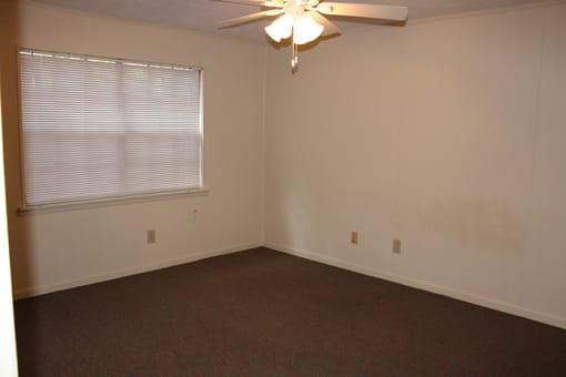 a bedroom with a ceiling fan and a window