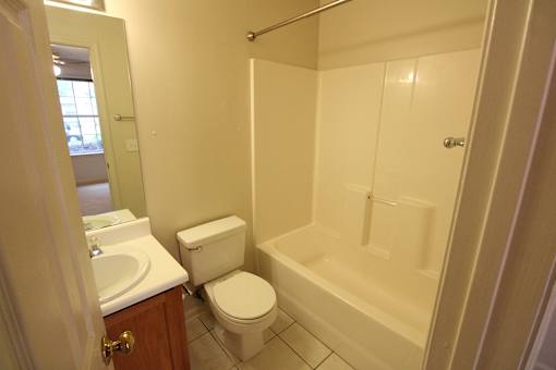 a bathroom with a toilet and a tub and a sink