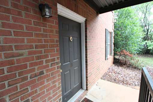 the front door of a brick building with a blue door