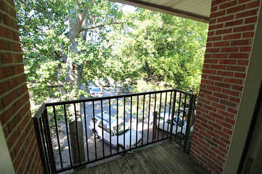 a balcony with a brick wall and trees