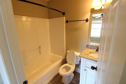 a bathroom with a toilet and a tub and a sink