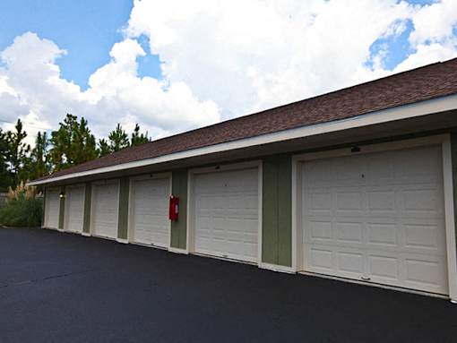 A long row of garage doors with one red and one green.