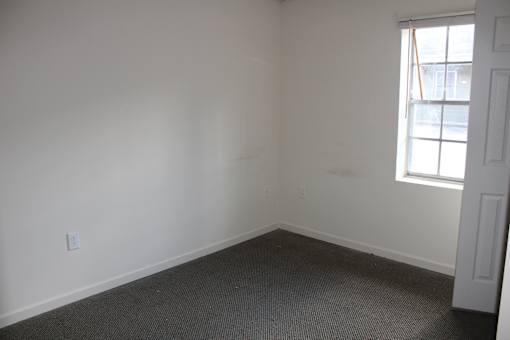 an empty room with white walls and a window