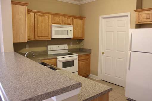 a kitchen with granite counter tops and wooden cabinets