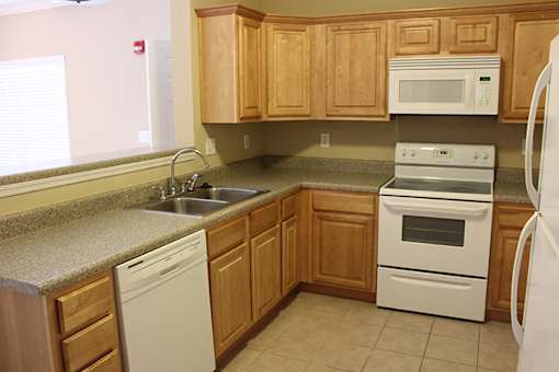 a kitchen with white appliances and wooden cabinets