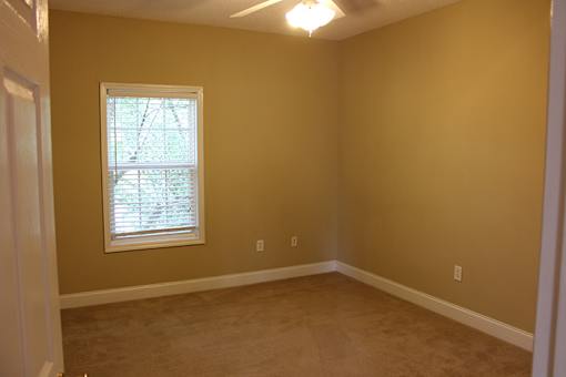 a empty room with a window and a carpet