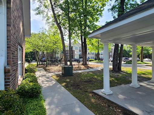 a sidewalk in front of a building with trees