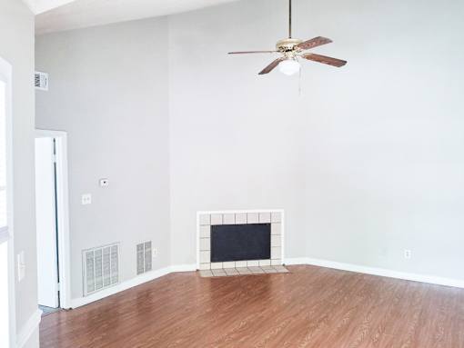 A room with a fireplace and a ceiling fan.