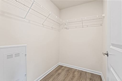 A white closet with a white door and a white cabinet.