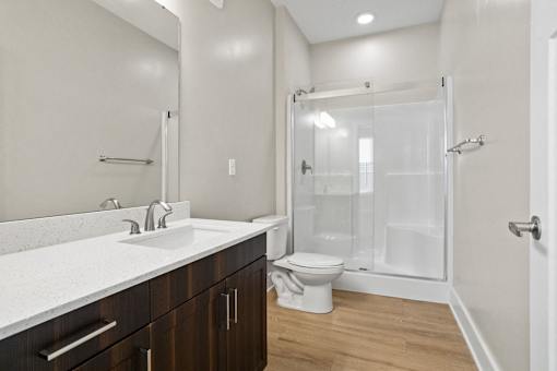 A white bathroom with a toilet, sink, and shower.