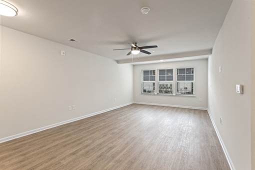 Empty room with a ceiling fan and a window.