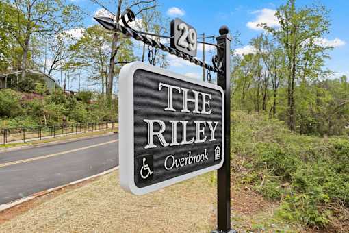 The Riley Overbrook sign is black and white with a tree in the background.