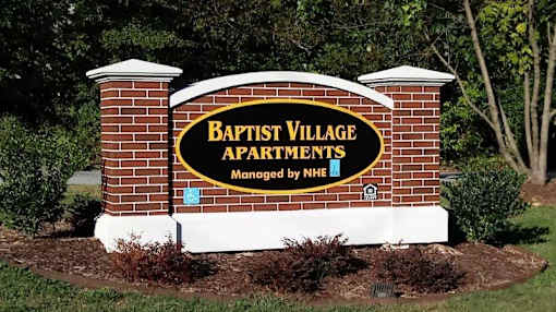 a sign for the apartments sign on a brick wall