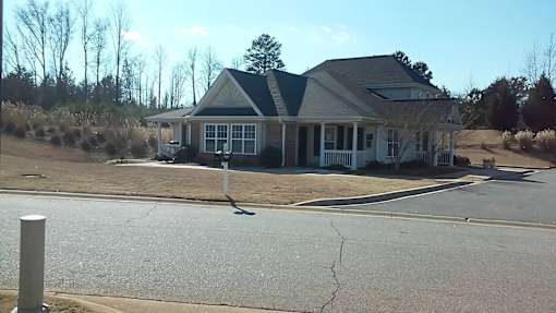 A house with a grey roof and a white fence.