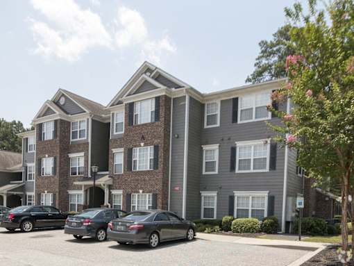 an apartment building with cars parked in front of it