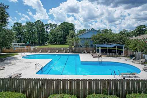 A large blue swimming pool surrounded by a wooden fence.