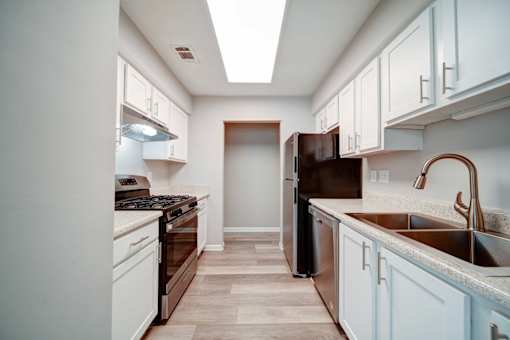 A kitchen with a white and brown color scheme.