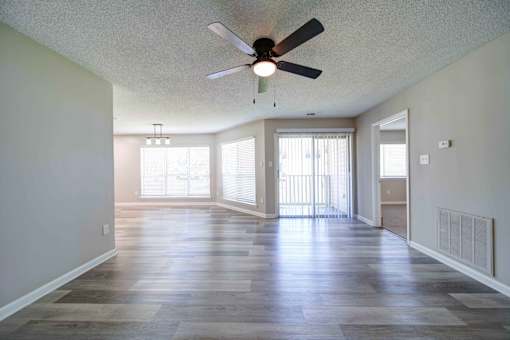 A spacious room with a ceiling fan and sliding glass doors.