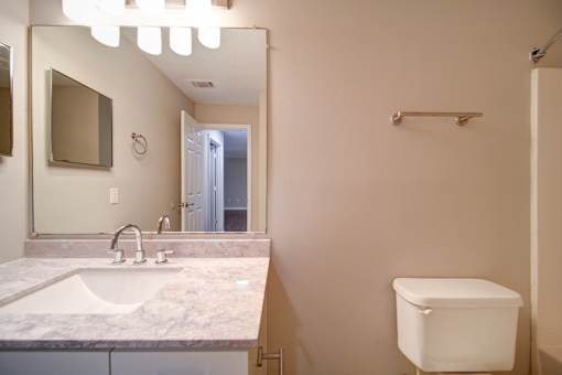 A white toilet sits next to a sink in a bathroom.