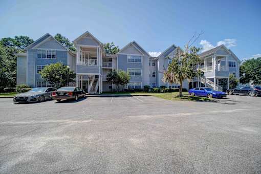 A parking lot with cars and a building in the background.
