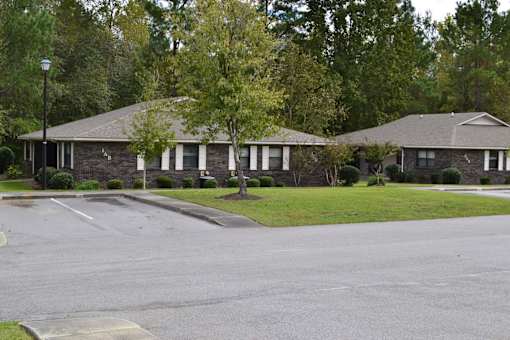 A street view of a residential area with houses and trees.
