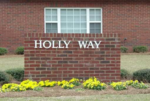 A brick wall with the words HOLLY WAY on it.