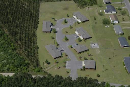 A bird's eye view of a residential area with houses and a winding road.