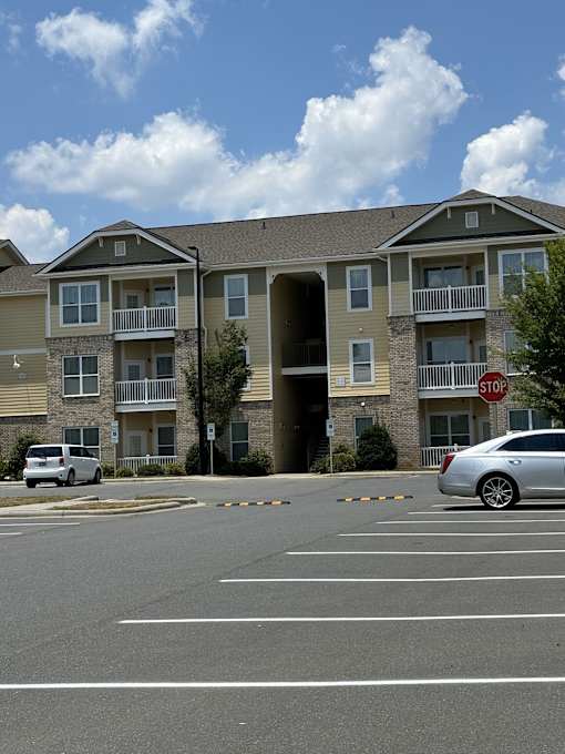 an apartment building with a stop sign in a parking lot