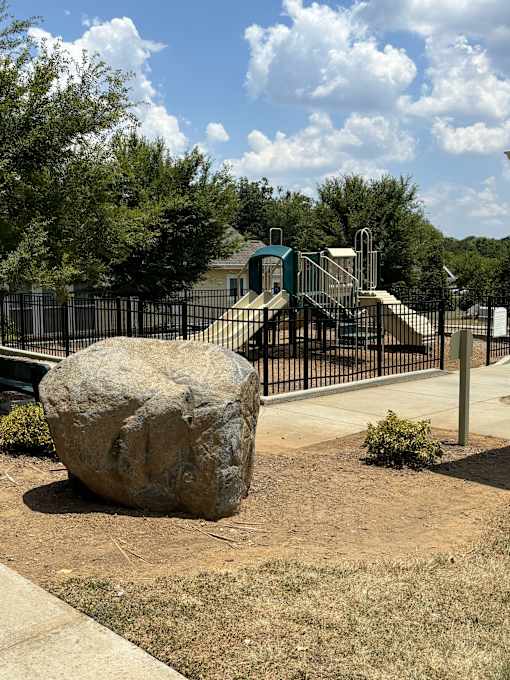 a large rock sitting in front of a playground
