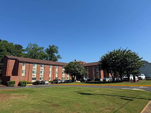 A large red brick building with a parking lot in front.