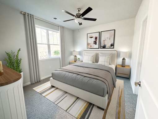 A bedroom with a large bed and a ceiling fan.