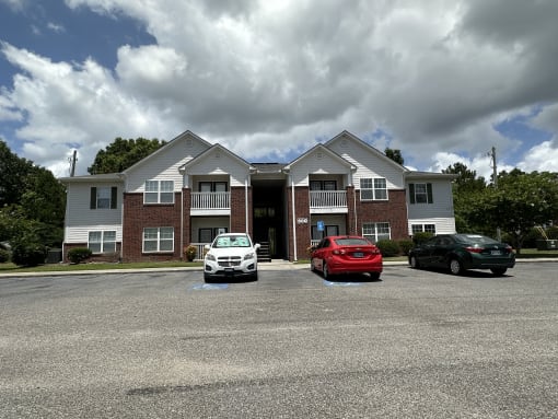a large apartment building with cars parked in front of it