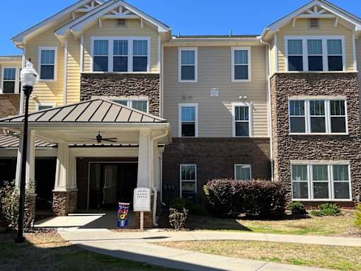 an apartment building with a sidewalk in front of it