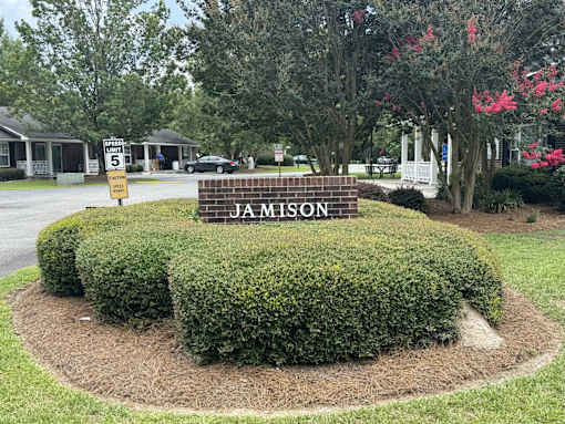 A sign that says Jamison is in front of a building.