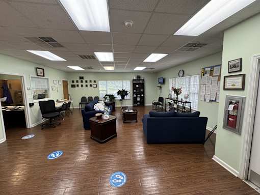 A room with a wooden floor and a few pieces of furniture.